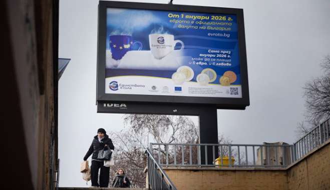 A woman passes by a billboard displaying Eurozone information campaign in Sofia, Saturday, Dec. 27, 2025. (AP Photo/Valentina Petrova)